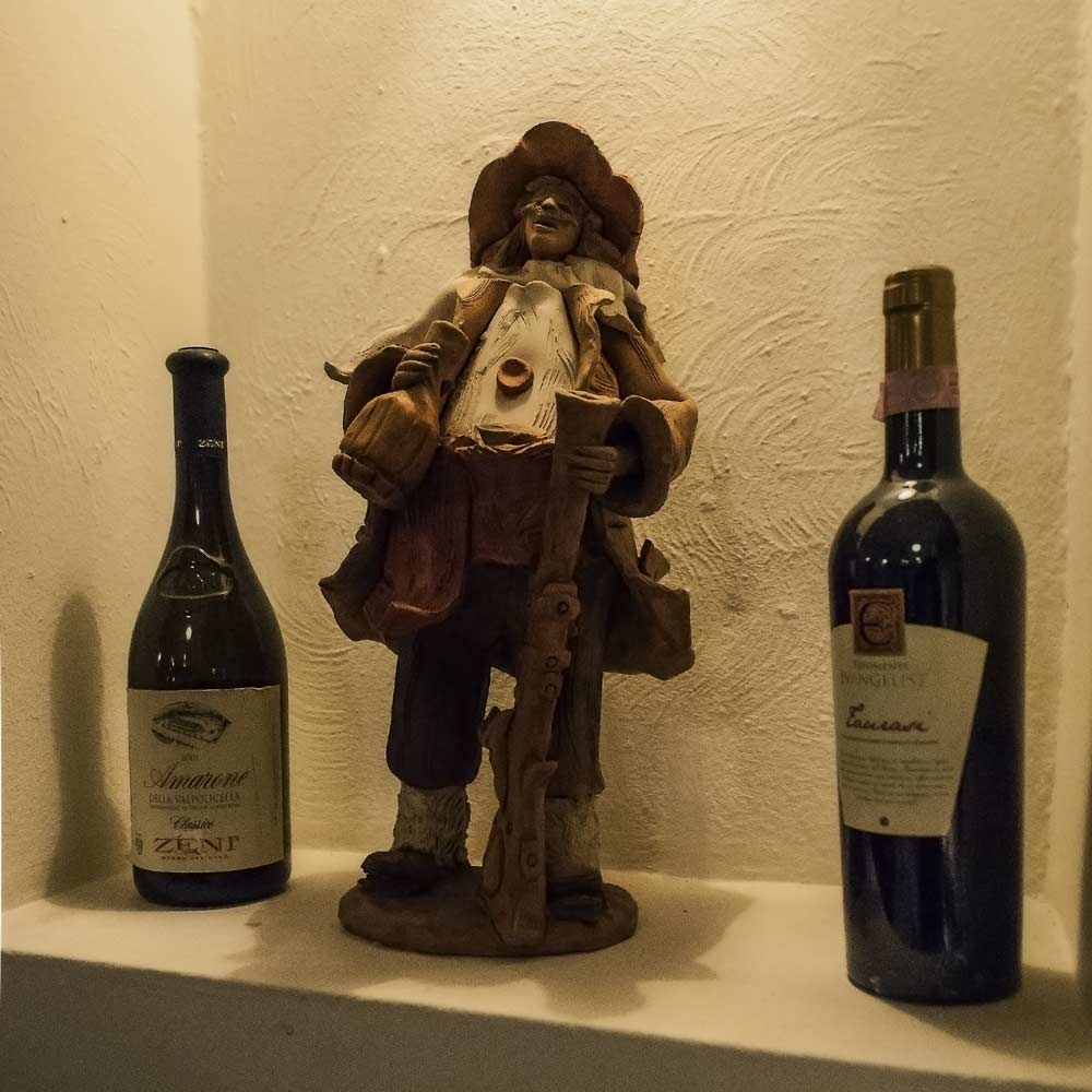 Weinflaschen und eine dekorative Figur im bisherigen Grissino